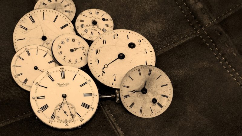 Group of Clock Faces on Black Background