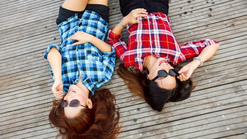 Two Ladies Laying Down on Dock with Sun Glasses on