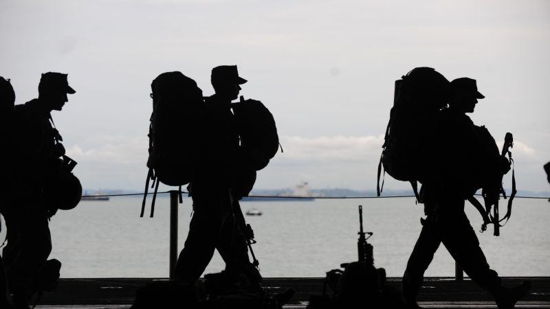 Military Men Departing with Packs On Back