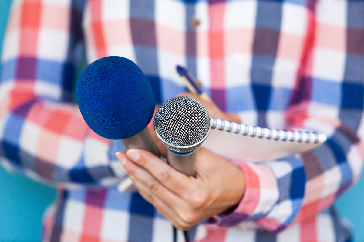 person-with-microphone-and-notepad-writing-5-elements-of-a-successful-pr-campaign