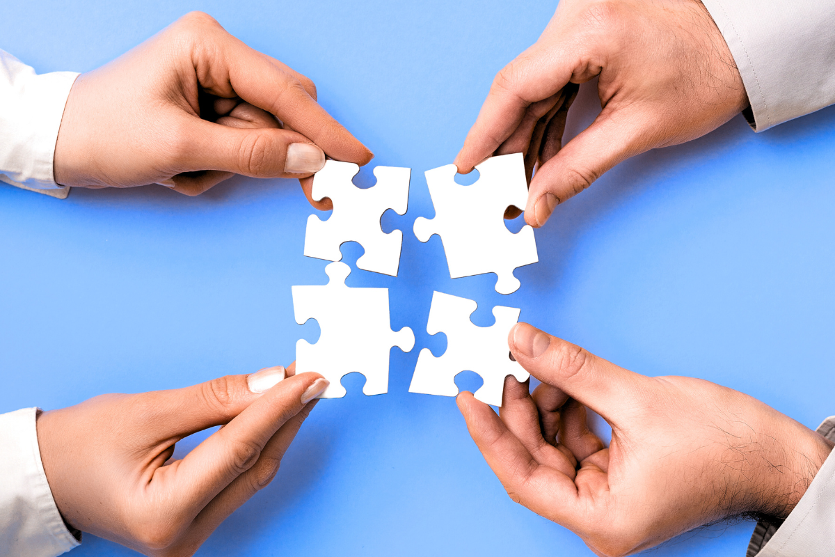 two-people-putting-puzzle-pieces-together