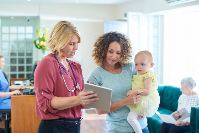 woman-holding-baby-talking-to-healthcare-provider