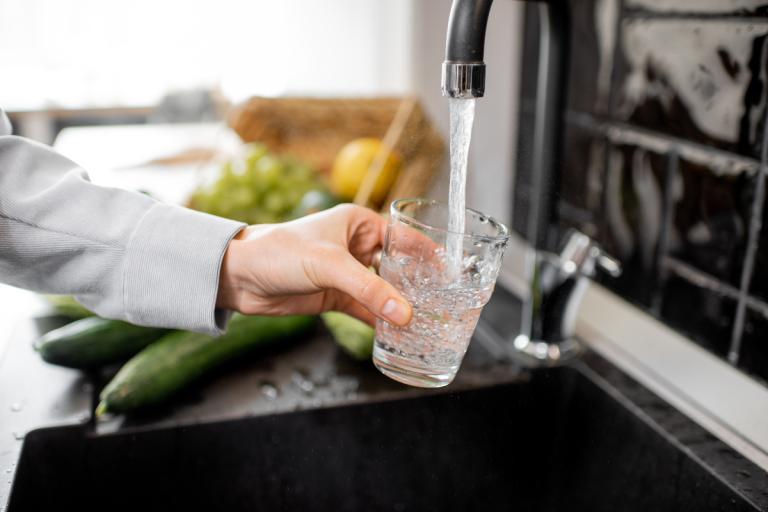 hand-filling-water-glass-under-a-faucet
