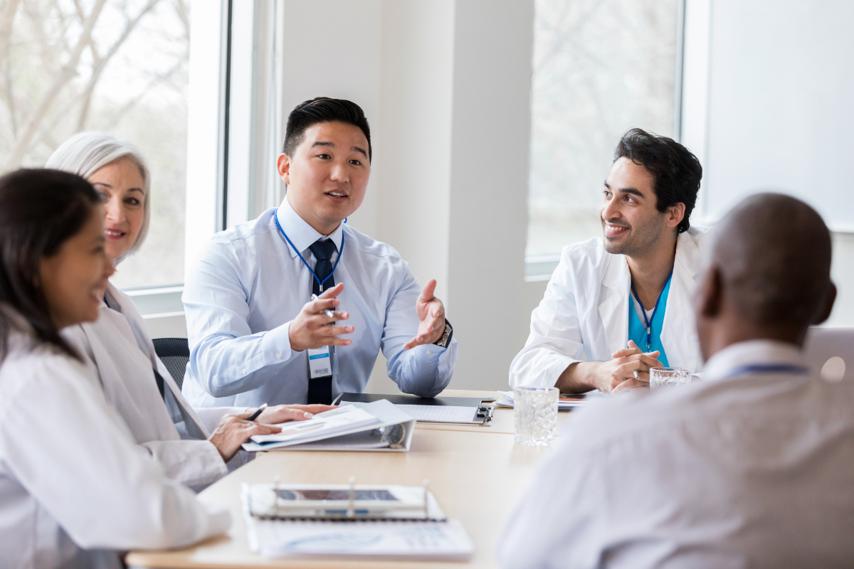 group-of-healthcare-professionals-sitting-around-a-table-with-an-administrator